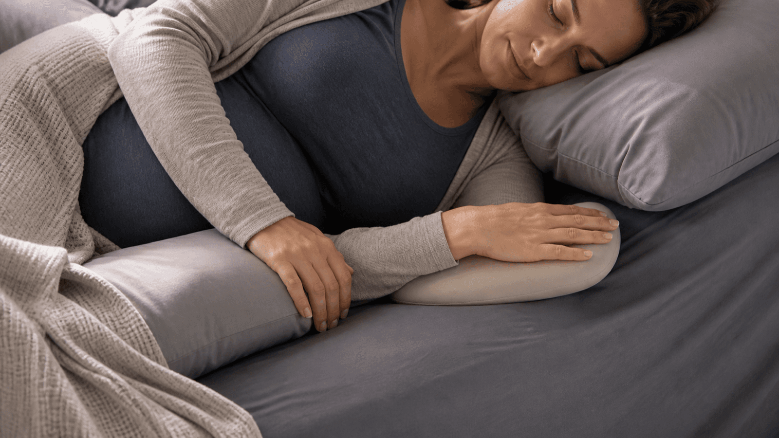 Pregnancy sleep setup with pillows and a neutral-position wrist support
