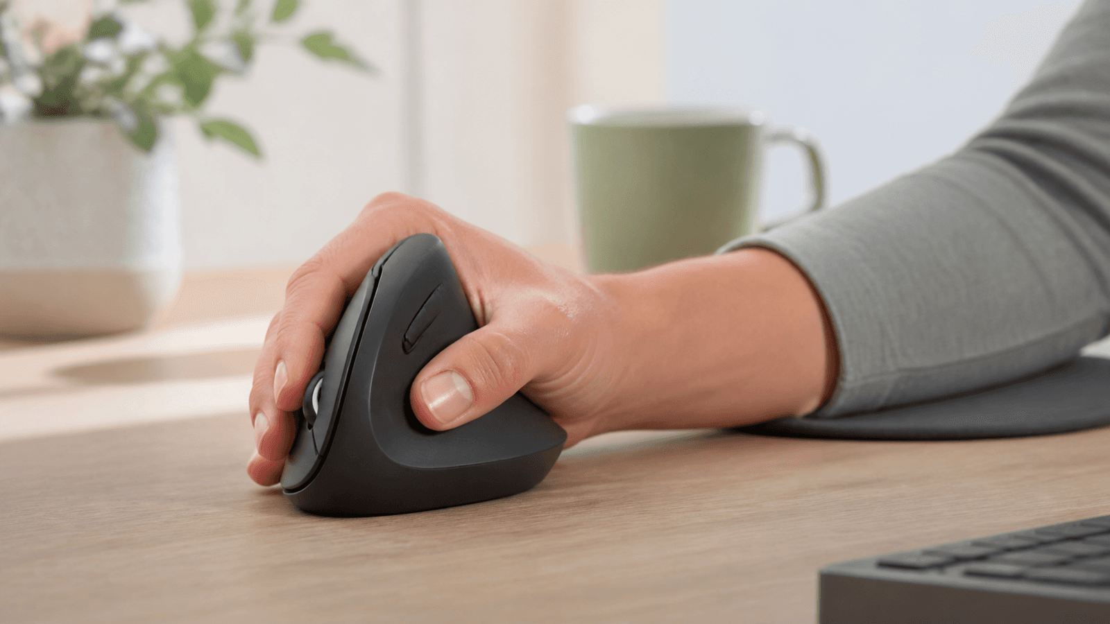 Adult resting a hand lightly on a vertical mouse